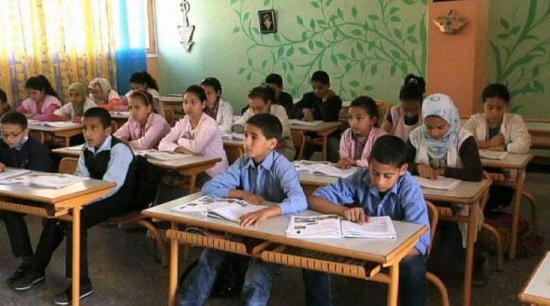 Children at desks in a school room in the Middle East.