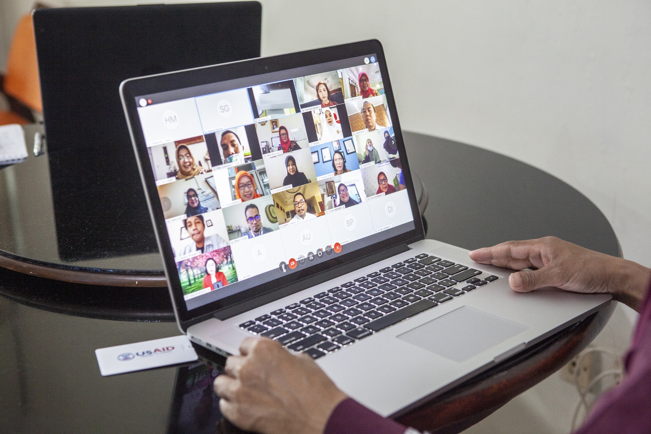 Image of a person participating in a video call using a laptop.